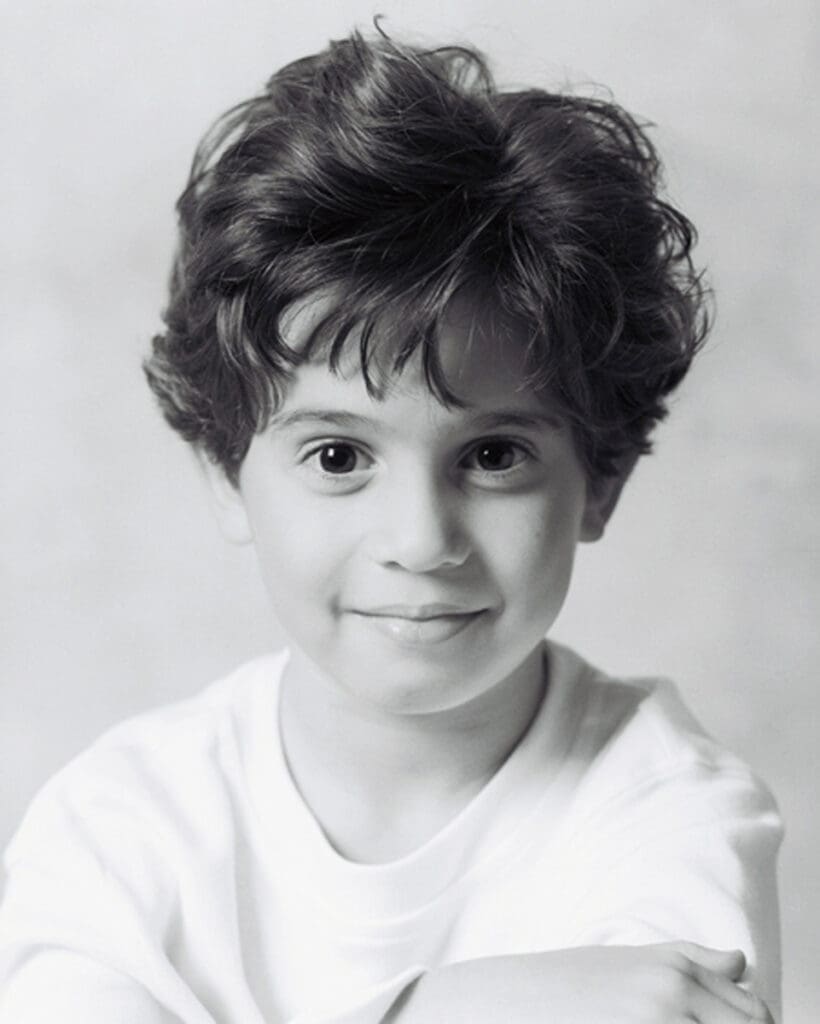 Black and white studio portrait of a young boy